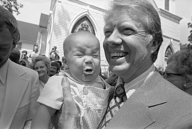 A baby cries next to Jimmy Carter in 1976