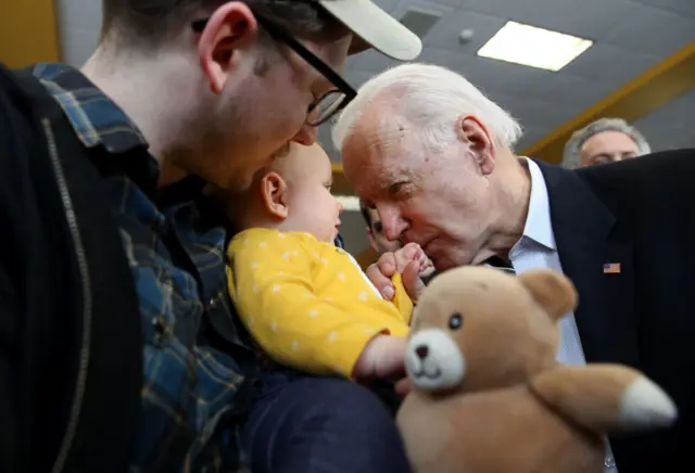 Biden smooches a baby on Sunday in Dubuque, Iowa