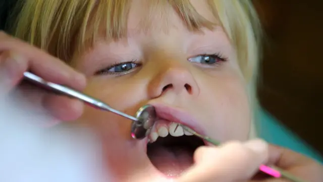 A child is examined by a dentist