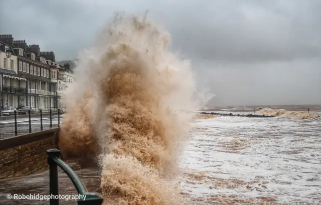 Waves crash against a sea wall at Sidmouth