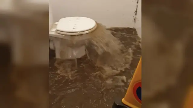 A toilet overflowing with flood water