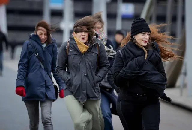 People walk against strong wind on the Erasmusbrug bridge, in Rotterdam, on February 9, 2020. during the storm Ciara in Harlingen, The Netherlands