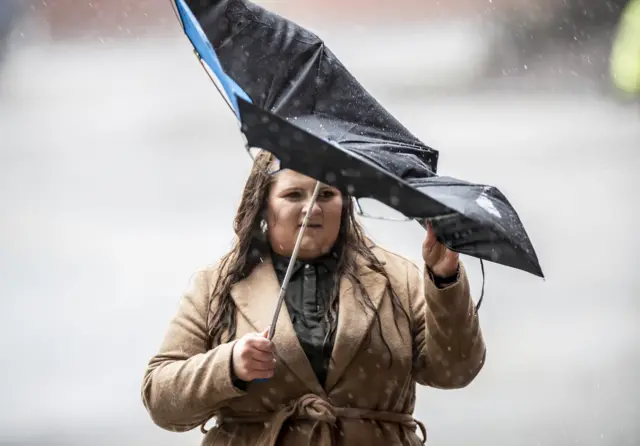 Woman's umbrella flips inside out