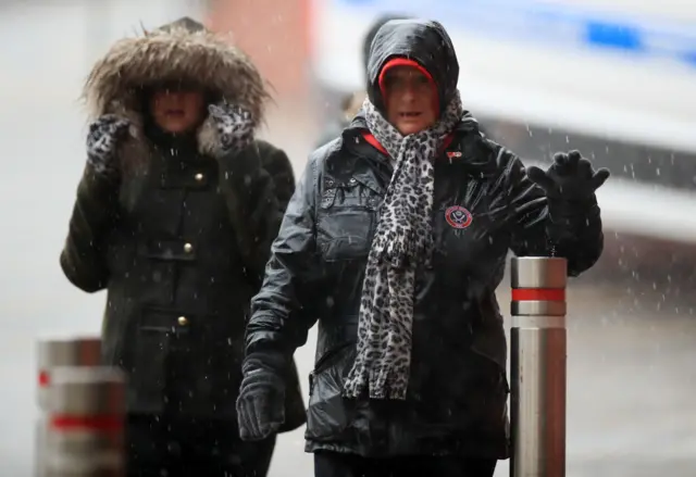 Two women walk in the rain