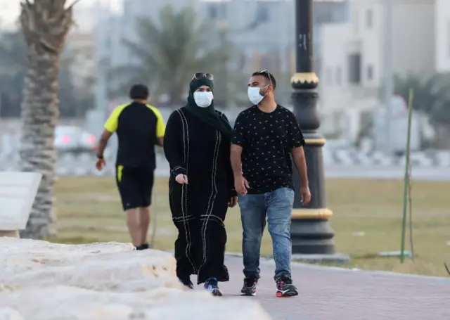 A couple wear protective face masks in Saudi Arabia