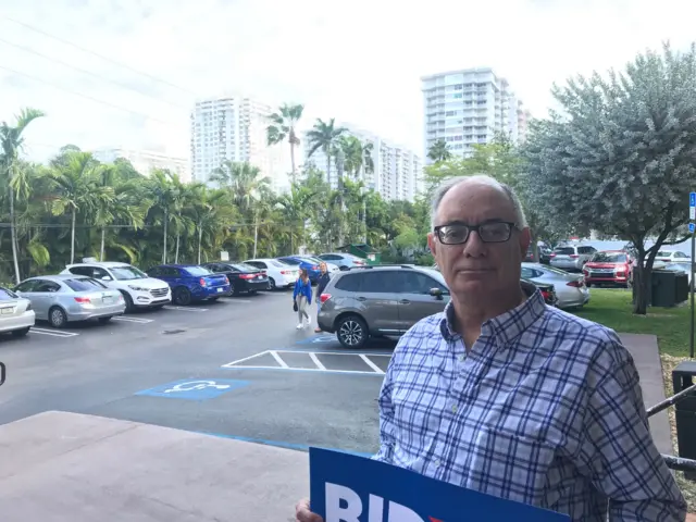 Voter Cary Fleishchman holds a Biden campaign sign