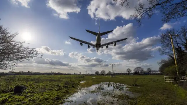 Plane flies over field