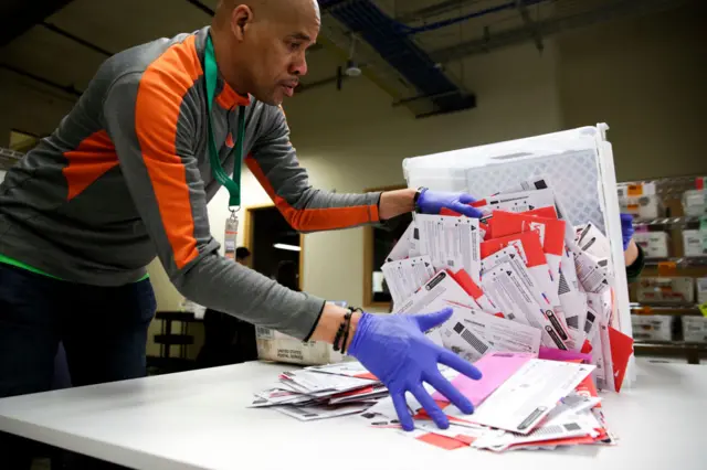 Election worker Erick Moss sorts vote-by-mail ballots for the presidential primary at King County Elections in Renton, Washington on March 10, 2020