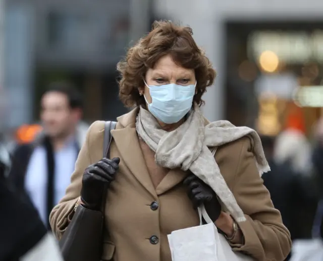 Woman in street wearing mask