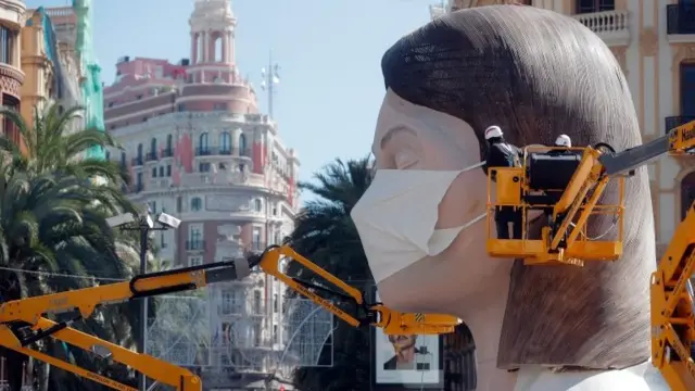 A mask is fixed to a Fallas sculpture in Valencia, eastern Spain, 11 March 2020