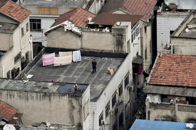 A man walks on a rooftop in Wuhan