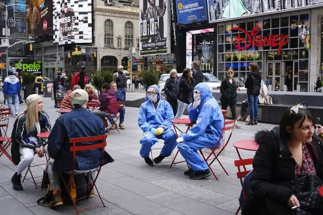 Two people wearing protective suits in Time Square