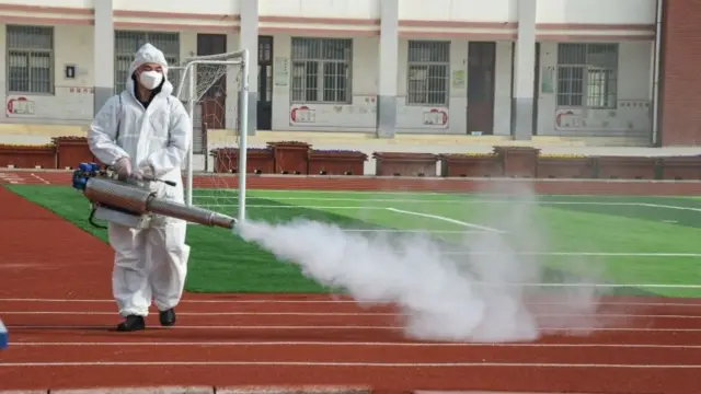 A worker cleans schools ahead of their reopening in Donghai, eastern China