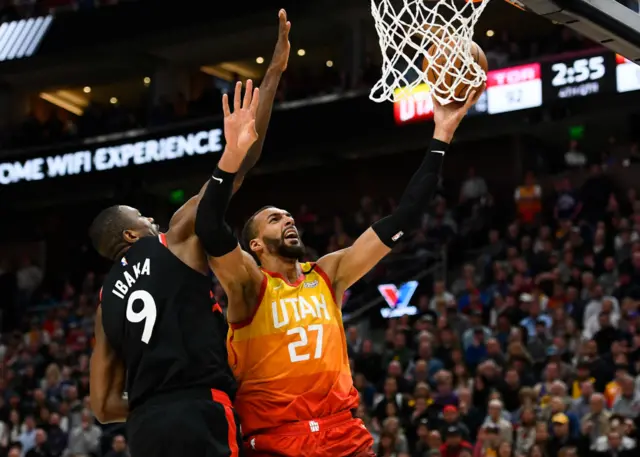 Rudy Gobert #27 of the Utah Jazz attempts a shot under Serge Ibaka #9 of the Toronto Raptors