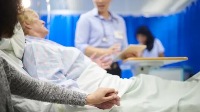 An elderly woman in a hospital bed