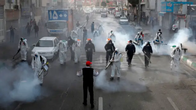 Iranian firefighters disinfect streets in the capital, Tehran, in a bid to halt the spread of coronavirus, 13 March 2020