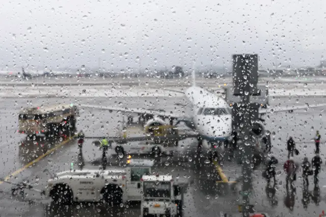 A plane is seen through glass at Edinburgh Airport during heavy rains, 4 March 2018