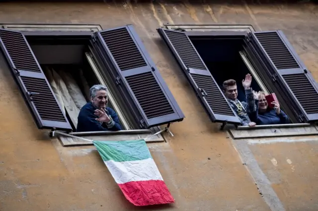 People sing from their home window in the Pigneto district, in Rome, on 14 March 2020