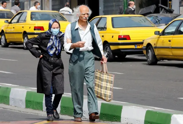 An Iranian couple walk arm in arm in Tehran