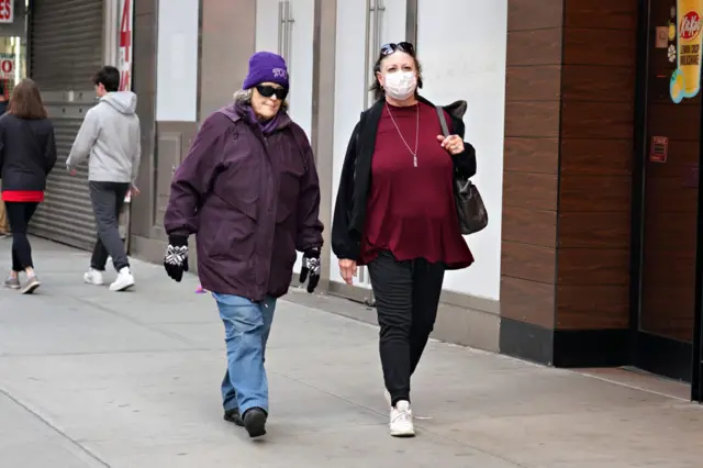 Women in New York City, one wearing a mask