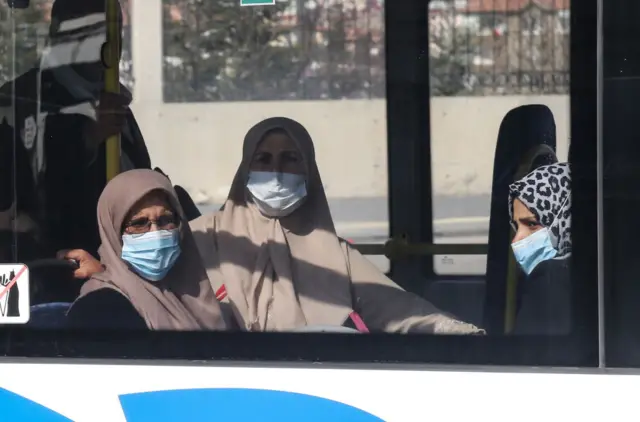 Turkish citizens wearing protective face masks sit in a bus as they are repatriated from the "umrah" pilgrimage in Saudi Arabia