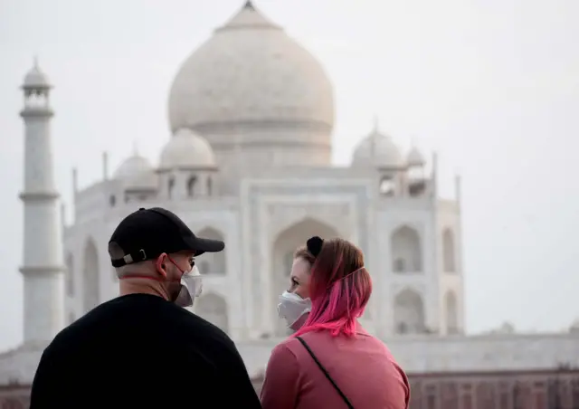 Tourists wear face masks as a preventive measure against the spread of the COVID-19 coronavirus outbreak, near Taj Mahal in Agra on March 5, 2020