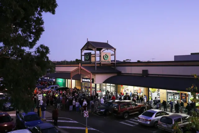 A crowd of people wait for a supermarket to open in Melbourne, Australia, on Tuesday