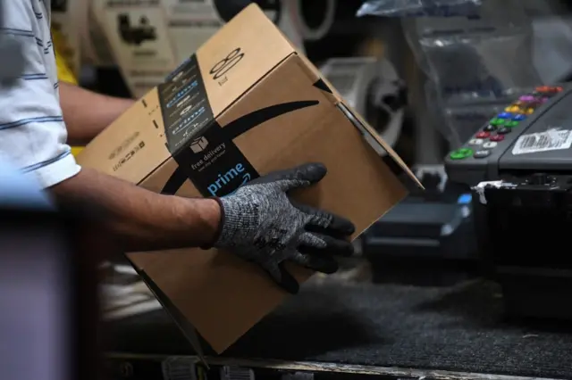 Worker assembles a box for delivery at the Amazon fulfilment centre.