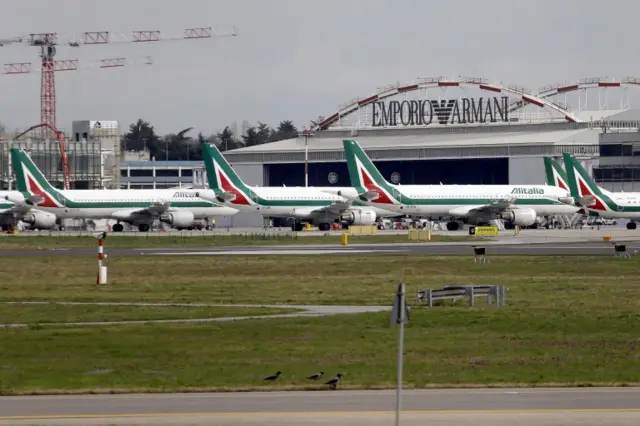 Aircraft of the Italian flag carrier Alitalia remain docked at the deserted Milan Linate Airport