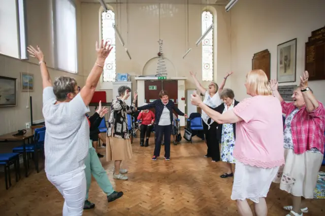 Elderly day care visitors enjoying an exercise class