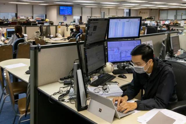 A stock broker follows the Hang Seng Index in Hong Kong.