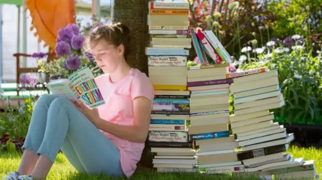 Woman reading books at Hay festival