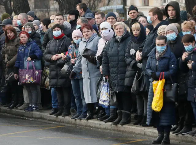 People at a bus stop in Kiev, 19 March