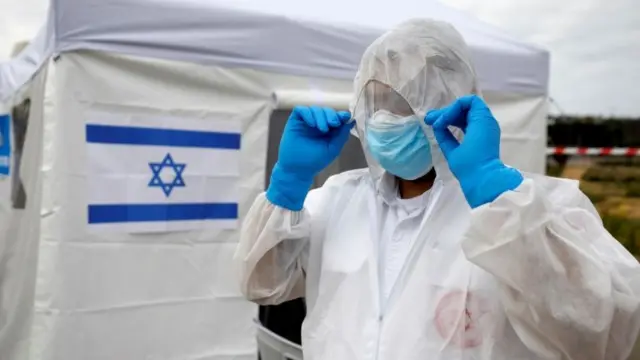 Paramedic in top-to-toe protective gear at a specialist coronavirus polling station