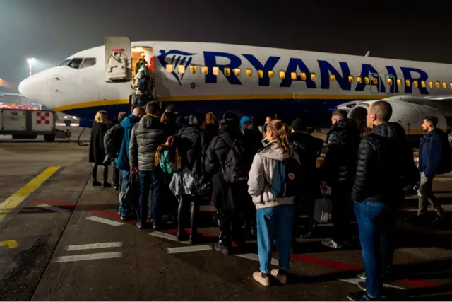 Passengers wait to board an aircraft of low-cost Irish airline Ryanair at Bergamo airport, Italy