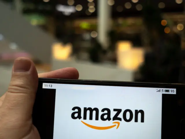 In this photo illustration the Amazon logo is seen displayed