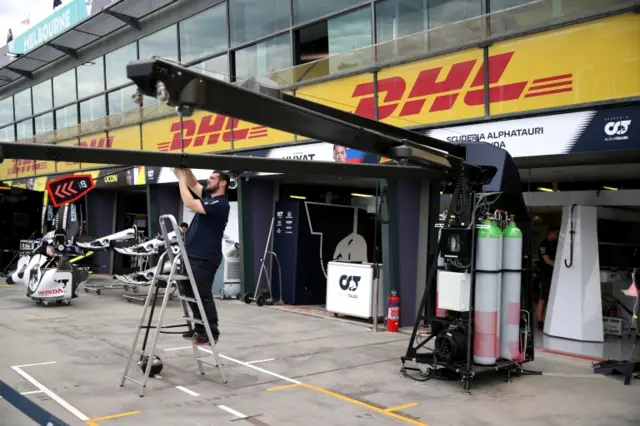 An AlphaTauri team member begins to pack up after it was announced the Australian Grand Prix would be cancelled