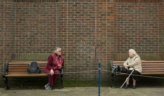 Women chatting from separate benches