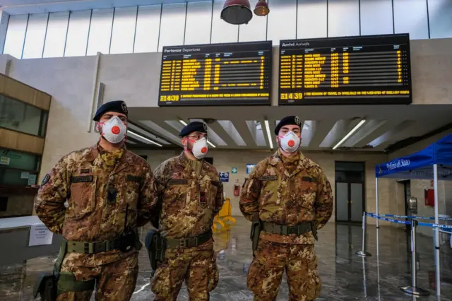 Italian soldiers stand guard and carry out checks at Palermo's central station