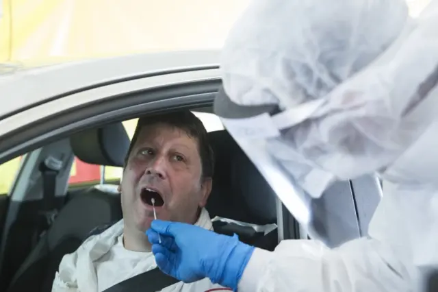 Israeli medical worker gives a swab test for coronavirus at a drive-through site during a presntation for the press before opening on 20 March in Tel Aviv, Israel.