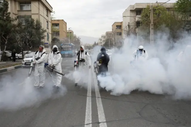 Iranian firefighters disinfect street in Tehran