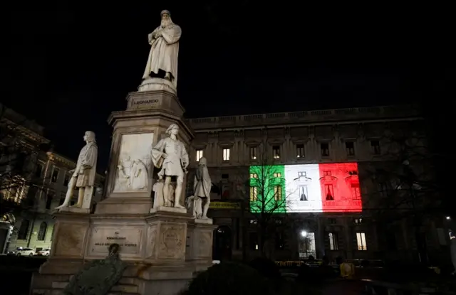 The Palazzo Marino building is seen illuminated with the colours of the Italian flag