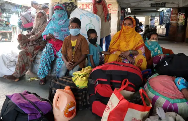 Indian stranded passengers sit as they look for the public transport after government banned interstate bus service, at general bus stand in Jammu, India, 19 March 2020.