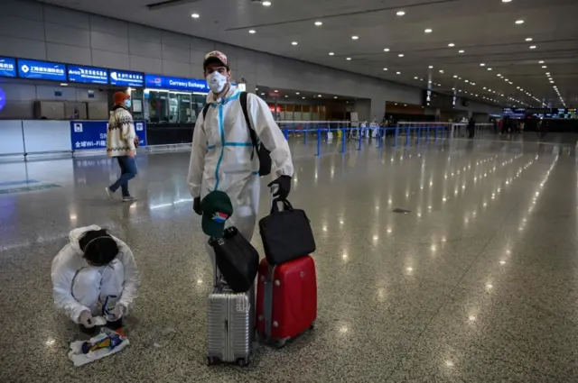 Travellers in protective gear at Shanghai airport