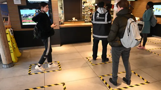 Tape marks the floor where customers should stand to practice social distancing to reduce the risk of spreading coronavirus at a McDonald"s restaurant in London, Britain, 21 March 2020. Britain"s Prime Minister Boris Johnson has urged UK citizens to avoid unnecessary social contacts, to work from home where possible, and to close schools, pubs and restaurants. Several European countries have closed borders, schools as well as public facilities, and have cancelled most major sports and entertainment events in order to prevent the spread of the SARS-CoV-2 coronavirus causing the Covid-19 disease.