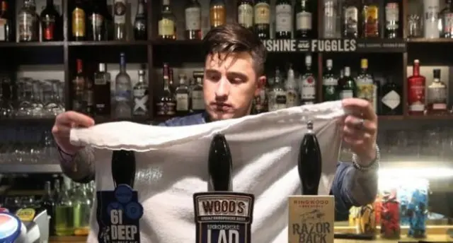 Man covering pumps in pub