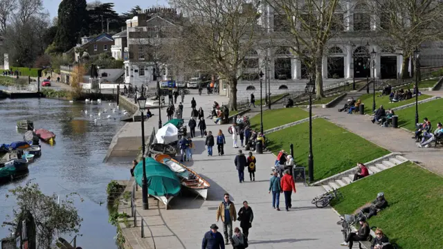 People are seen relaxing along the waterfront beside the River Thames, as the number of coronavirus disease cases (COVID-19) grow around the world, Richmond, south west London