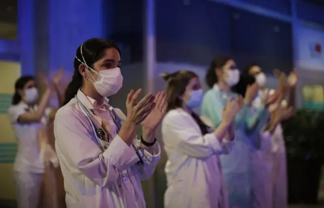 Health officials applauded in return to Spanish police who paid respect to health workers fighting coronavirus pandemic by applauding.