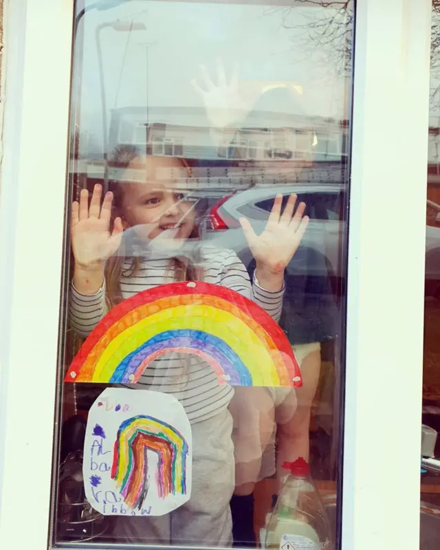 Layla Briggs' children in the window showing off their art work