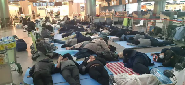 Migrant workers lie on the floor of Moscow's Vnukovo airport